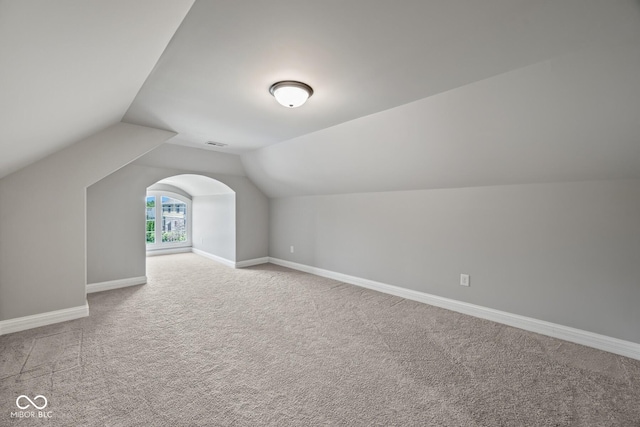 bonus room featuring lofted ceiling and carpet flooring