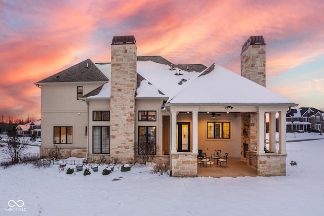 snow covered rear of property featuring ceiling fan