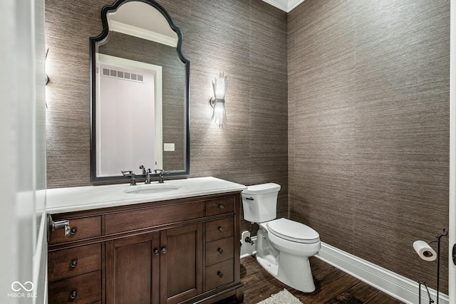 bathroom with vanity, hardwood / wood-style floors, crown molding, and toilet