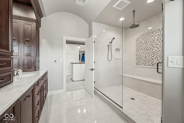 bathroom featuring lofted ceiling, vanity, and a shower with door