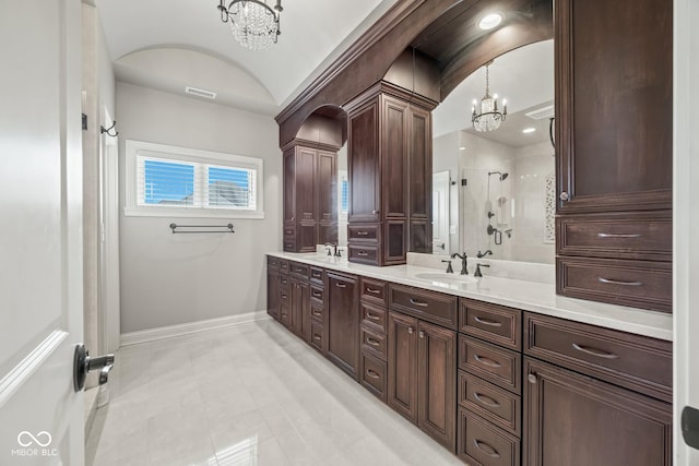 bathroom featuring vanity, a chandelier, and a shower with door