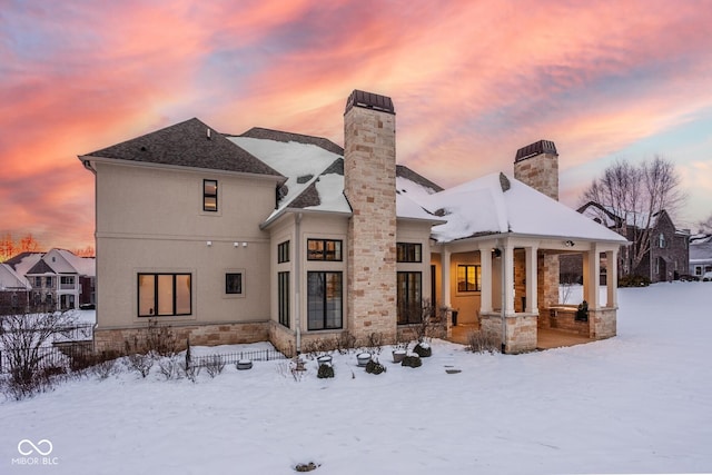 snow covered rear of property featuring a porch