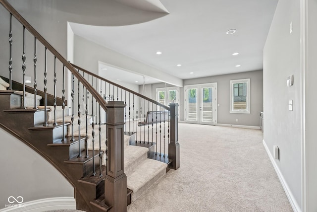 stairway featuring french doors and carpet floors