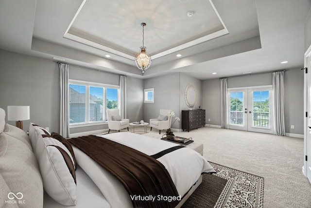 carpeted bedroom featuring french doors, a raised ceiling, multiple windows, and access to outside