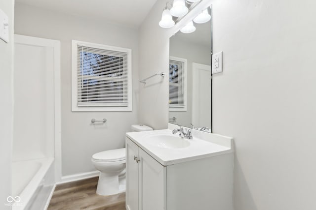 bathroom with hardwood / wood-style flooring, toilet, and vanity