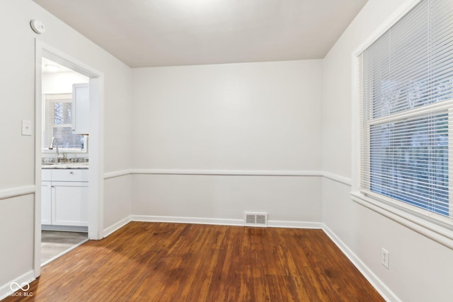 unfurnished room with sink and dark hardwood / wood-style flooring