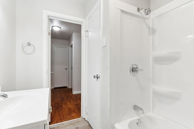 bathroom with hardwood / wood-style flooring, shower / tub combination, and vanity