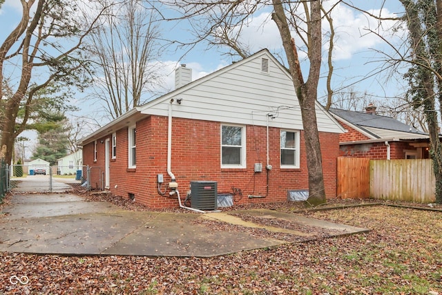 view of side of home with central AC unit and a patio