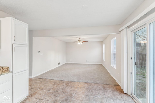 carpeted spare room featuring ceiling fan