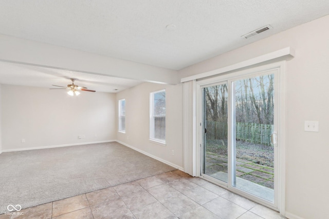 tiled spare room with plenty of natural light and ceiling fan