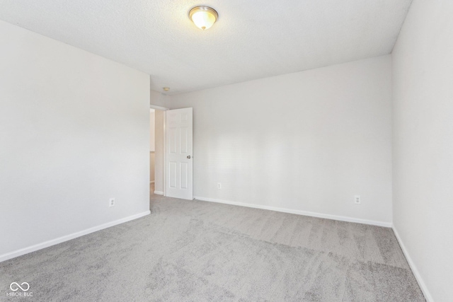 carpeted empty room featuring a textured ceiling