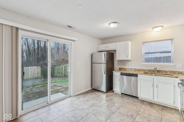 kitchen with sink, white cabinetry, a textured ceiling, and appliances with stainless steel finishes