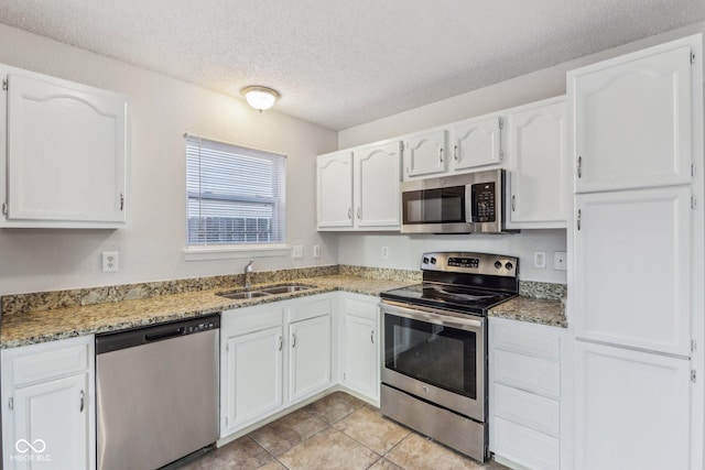 kitchen featuring sink, a textured ceiling, white cabinets, and stainless steel appliances