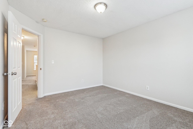 carpeted spare room featuring a textured ceiling