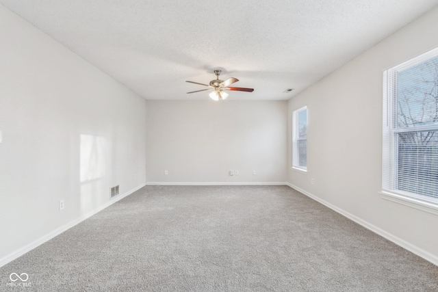 carpeted empty room featuring a textured ceiling and ceiling fan