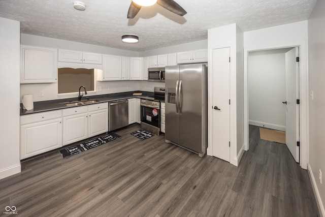 kitchen with sink, white cabinetry, dark hardwood / wood-style floors, ceiling fan, and stainless steel appliances