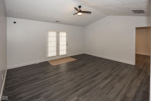 spare room with ceiling fan, dark hardwood / wood-style floors, vaulted ceiling, and a textured ceiling