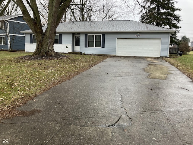 single story home with a garage and a front lawn