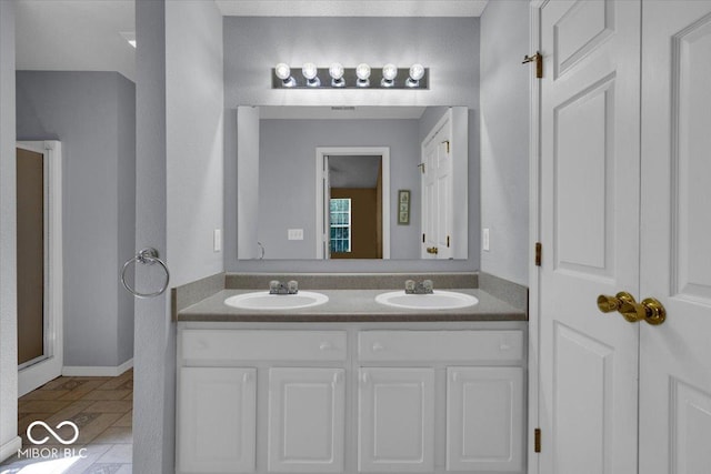 bathroom featuring tile patterned floors, a shower with door, and vanity