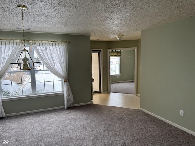 carpeted spare room featuring a textured ceiling