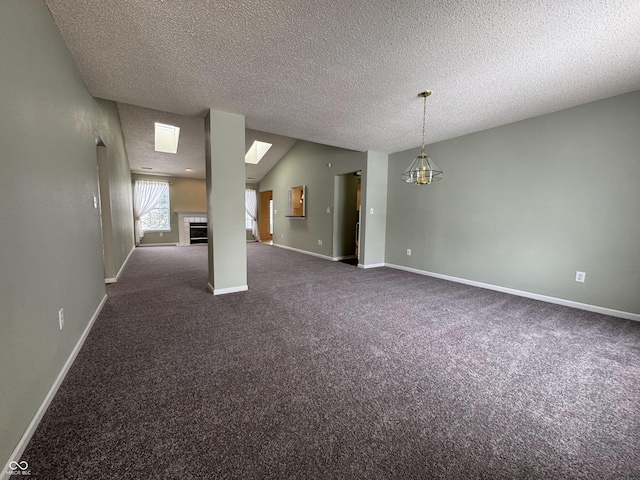 carpeted empty room featuring lofted ceiling, a textured ceiling, and a chandelier