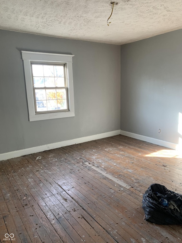 unfurnished room featuring hardwood / wood-style floors and a textured ceiling