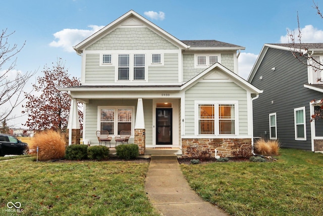 craftsman-style home featuring covered porch and a front lawn