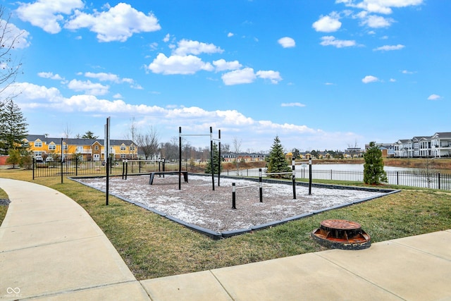 view of playground featuring a water view, a yard, and an outdoor fire pit