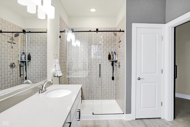 bathroom featuring a tile shower, vanity, and hardwood / wood-style floors