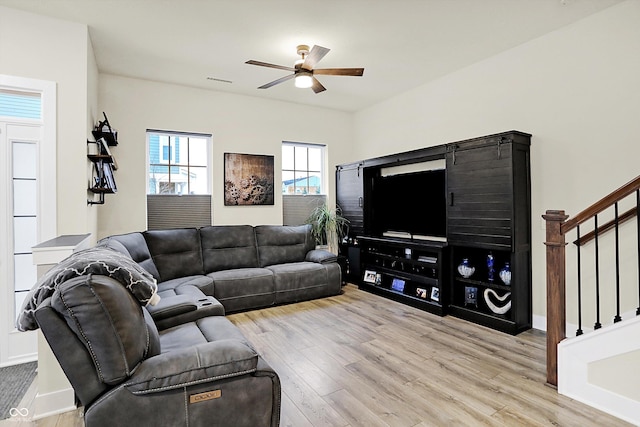 living room with light hardwood / wood-style flooring and ceiling fan