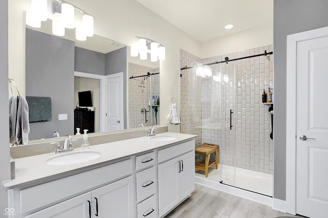 bathroom with vanity, wood-type flooring, and an enclosed shower