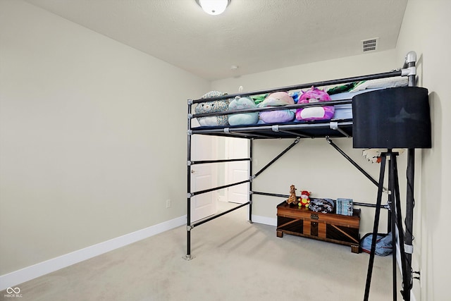 carpeted bedroom featuring a textured ceiling