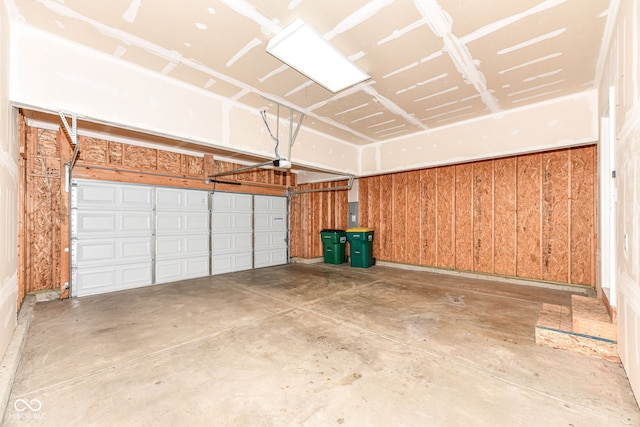 garage with wood walls and a garage door opener