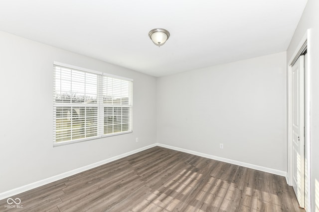 unfurnished bedroom featuring dark hardwood / wood-style flooring and a closet