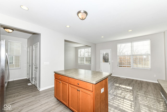 6927 Park Grove Blvd, Whitestown, IN 46075 - kitchen with stainless steel refrigerator, light wood-style flooring, recessed lighting, brown cabinets, and open floor plan