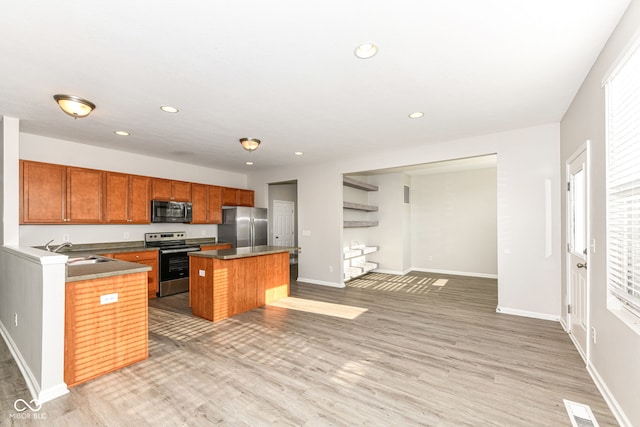 6927 Park Grove Blvd, Whitestown, IN 46075 - kitchen featuring appliances with stainless steel finishes, light wood-style flooring, a kitchen island, recessed lighting, and open floor plan