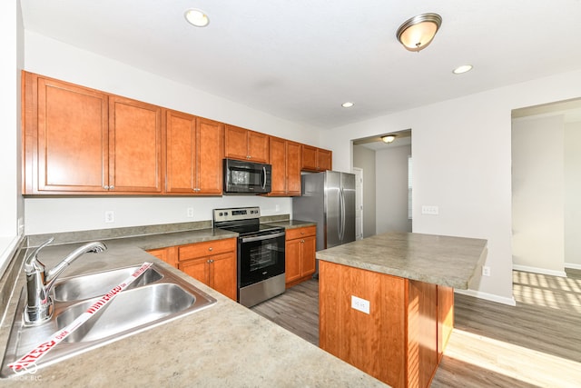 6927 Park Grove Blvd, Whitestown, IN 46075 - kitchen featuring stainless steel appliances, light wood-type flooring, recessed lighting, a kitchen island, and brown cabinets