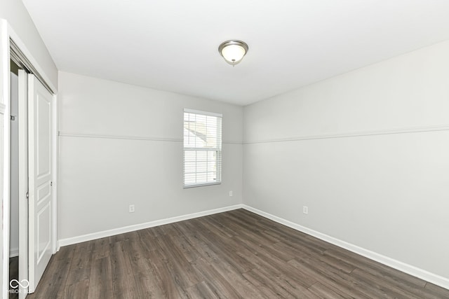 unfurnished bedroom with dark hardwood / wood-style floors and a closet