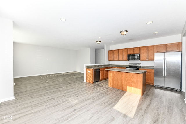 6927 Park Grove Blvd, Whitestown, IN 46075 - kitchen featuring stainless steel appliances, open floor plan, brown cabinetry, light wood-style floors, and recessed lighting