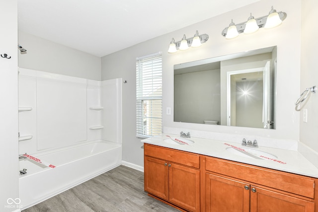 full bathroom with shower / washtub combination, hardwood / wood-style floors, vanity, and toilet