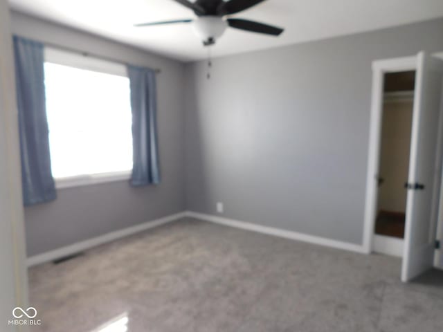 unfurnished bedroom featuring carpet, ceiling fan, and a closet