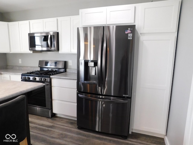 kitchen with white cabinetry, appliances with stainless steel finishes, and dark wood-type flooring