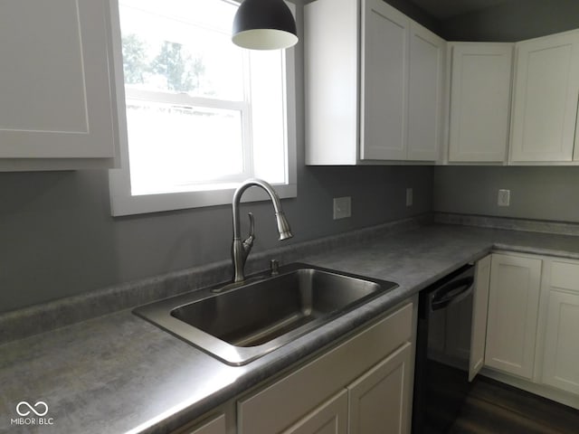 kitchen featuring white cabinetry, black dishwasher, and sink