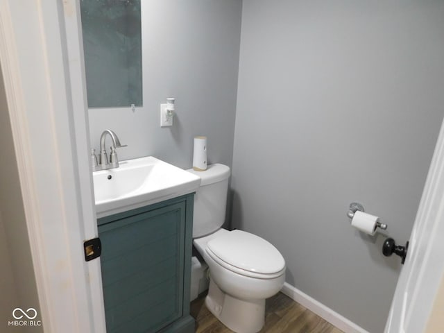 bathroom with vanity, toilet, and hardwood / wood-style floors