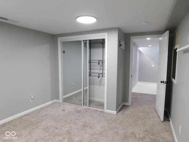 unfurnished bedroom with light carpet and a closet