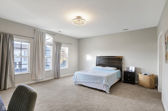 bedroom with light carpet and multiple windows