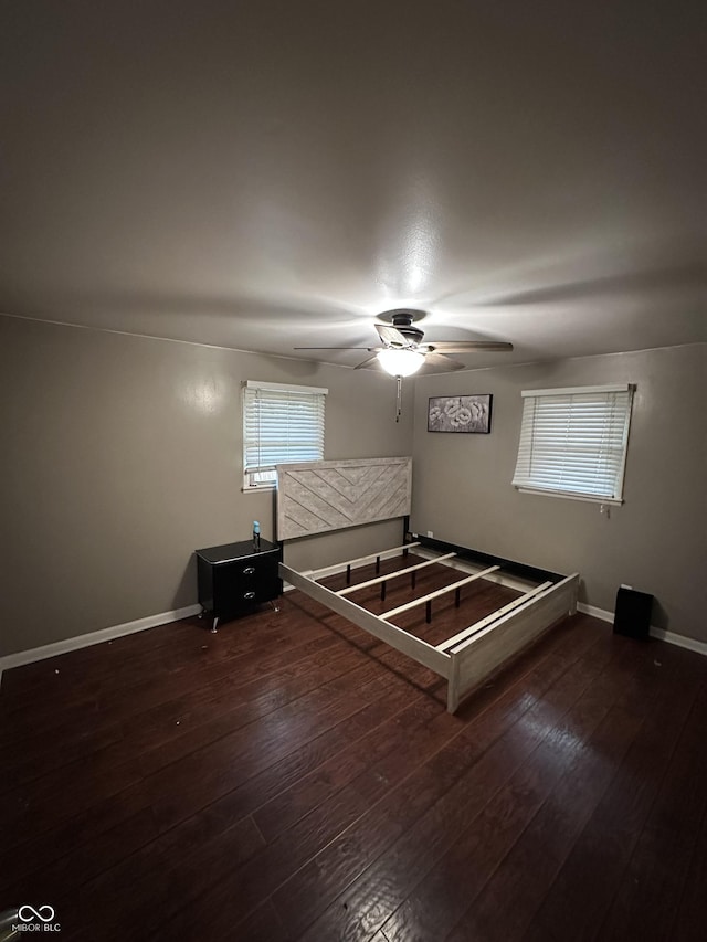 unfurnished bedroom featuring ceiling fan and dark wood-type flooring