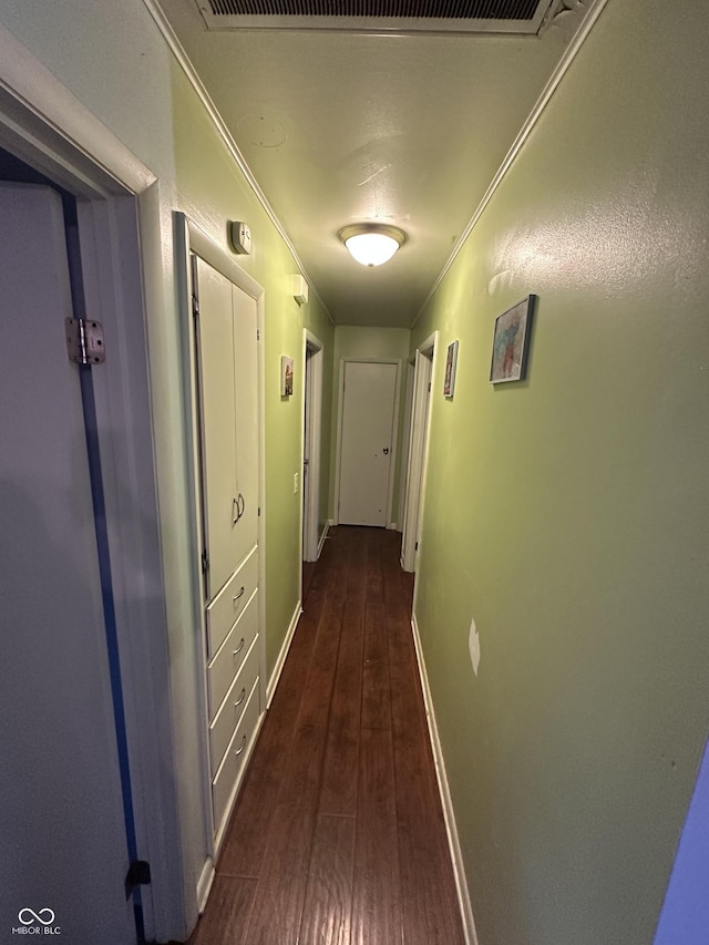 hall with dark hardwood / wood-style flooring and crown molding