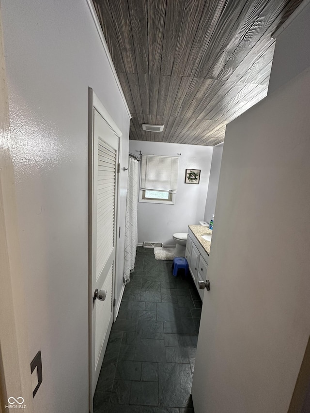 bathroom featuring vanity, toilet, and wood ceiling