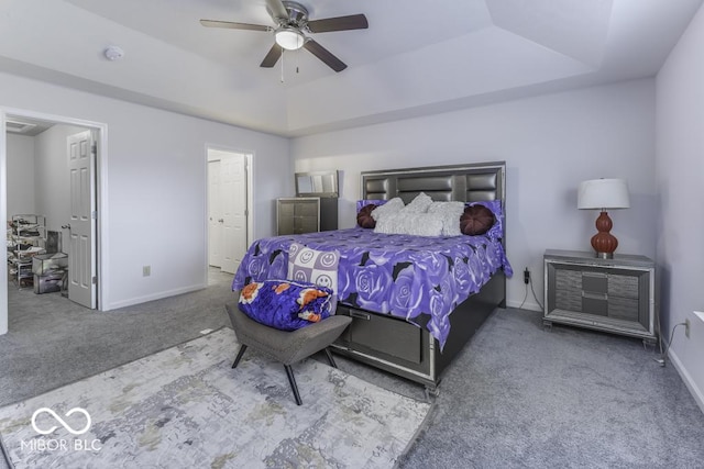 bedroom featuring ceiling fan, carpet floors, and a tray ceiling